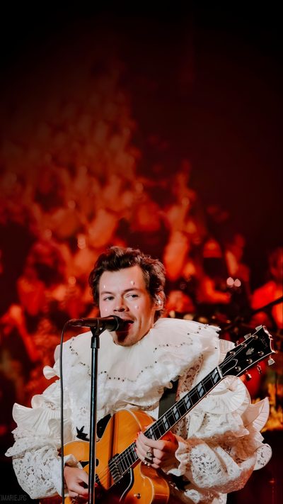 a man that is standing up with a guitar in front of his face and singing into a microphone Harry Styles Happy Halloween Iphone One Direction Pumpkin Painting Ideas, Harry Styles Crown, One Direction Halloween, maroon