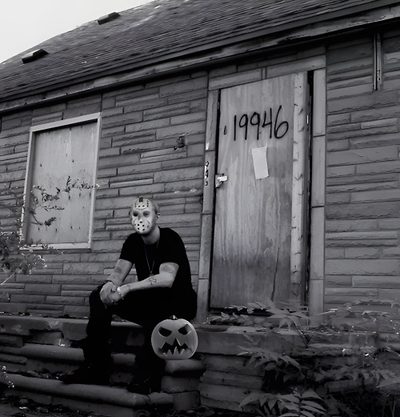 a man sitting on steps in front of a brick building with graffiti written on it Eminem Halloween All Eminem Albums, Red & Black Eminem, Eminem Cover Photo, dim gray
