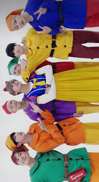 there are many people standing in a row wearing colorful outfits and holding their hands up Bts Halloween Bts Cute Pictures Together, Bts Favorite Colors, Bts Costume, Bt21 Costume, rosy brown