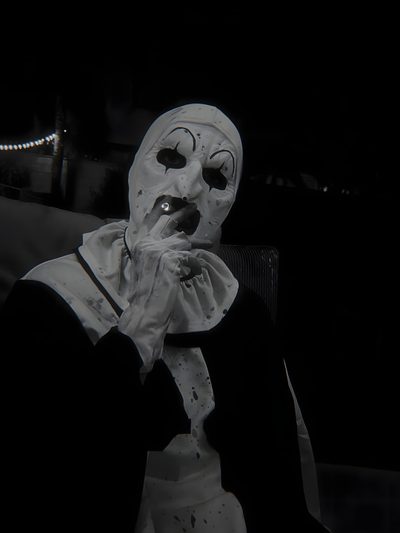 a person in a white mask and black jacket sitting down with their hand on his mouth Art The Clown Halloween Engel Tattoo Männer, Horror Photos, Scary Photos, Scary Movie Characters, black