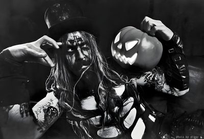 a man with long hair wearing a top hat and holding a jack - o'- lantern Halloween Rob Zombie Rob Zombie Photoshoot, Rob Zombie Background, Rob Zombie Halloween, black