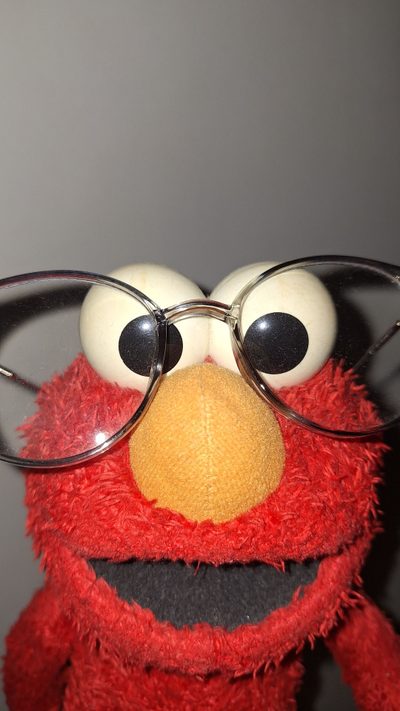 a close up of a stuffed animal wearing glasses Elmo Halloween Funny Backgrounds Elmo, Pfp For Contacts, Elmo X Eyes, Elmo Halloween, dim gray