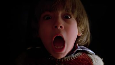 a young boy with his mouth open in the dark, making a shocked face and looking at the camera The Shining Laptop Halloween The Shining 1980 Danny, The Shining 1980 Movie Stills, Shining 1980, black
