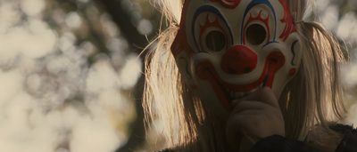 a woman wearing a clown mask with long blonde hair is holding her face up to the camera Halloween 2007 Rob Zombie Halloween Movie, Friday The 13th Rob Zombie, Halloween 2 Rob Zombie, dark olive green
