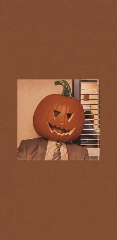 a man wearing a suit and tie with a pumpkin on his head in front of him Dwight Halloween Dwight Schrute Iphone, Fall Phone Backgrounds Aesthetic, Halloween Lock Screen, sienna