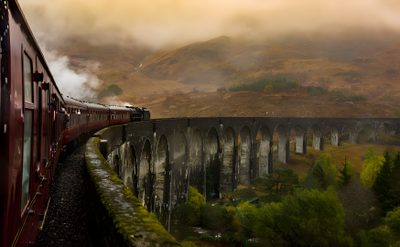a train traveling over a bridge in the mountains Halloween Train Harry Potter Background Laptop Aesthetic, Hogwarts Mountain, Laptop Hd 1080p Aesthetic Harry Potter, dark olive green