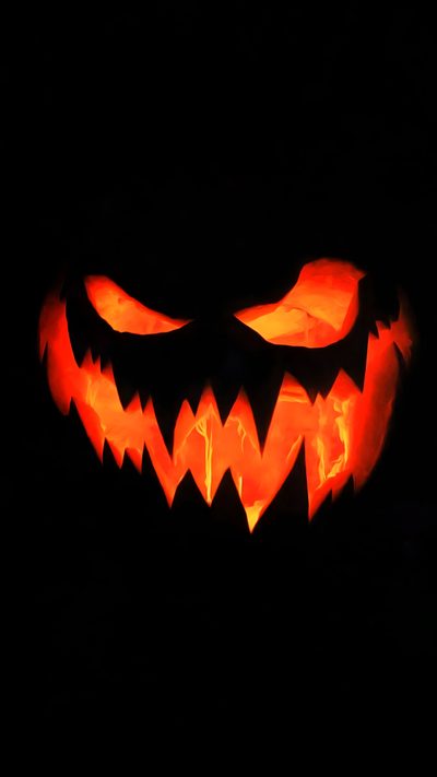 a carved pumpkin with glowing eyes in the dark Black And Orange Halloween Evil Pumpkin, Black Light Posters, Halloween Backgrounds,