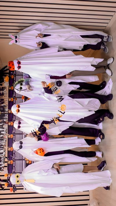 a group of people standing next to each other in front of a wooden table with halloween decorations on it Bts Halloween Laptop Bts Theme, Bts Thanksgiving, Bts Pumpkin Painting, Bts Fall, Bt21 Halloween, rosy brown