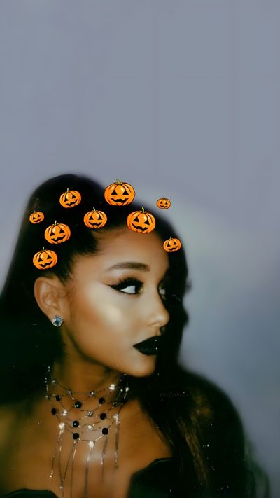 a woman with black makeup and orange pumpkins on her head is shown from the side Ariana Grande Halloween Ariana Grande Pumpkin, Ariana Grande Jack Skellington, Ariana Grande Fall, gray