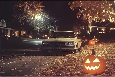 two pumpkins on the ground in front of a car with jack - o'- lanterns 80s Halloween Aesthetic Halloween Movie Desktop, 90s Aesthetic Halloween, 80s Aesthetic Halloween, dark slate gray