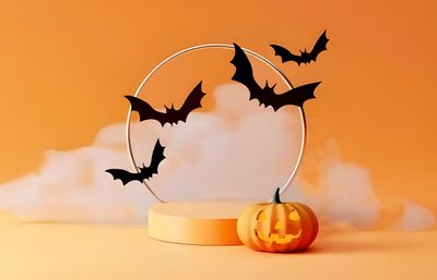 a pumpkin with bats flying around it Halloween Podium Halloween Podium, Halloween Themed Product Photoshoot, Halloween Product Photoshoot, peru