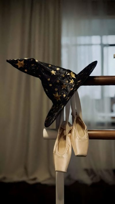 a pair of ballet shoes hanging from a rail with a hat on top of it Halloween Ballerina Ballerina Witch, Witches Dance, Cover, Witch Aesthetic, dark olive green