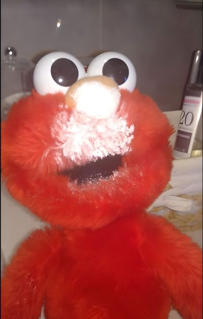 a red stuffed animal with big eyes and googly eyes Elmo Halloween Creative Elmo-themed Party, Elmo With Powdered Sugar, Elmo With Powdered Sugar On Face, sienna