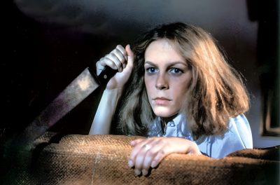 a woman sitting on top of a couch holding a knife Halloween 1978 Halloween Movies In Order, Laurie Strode, Halloween 2 Laurie Strode, dark slate gray