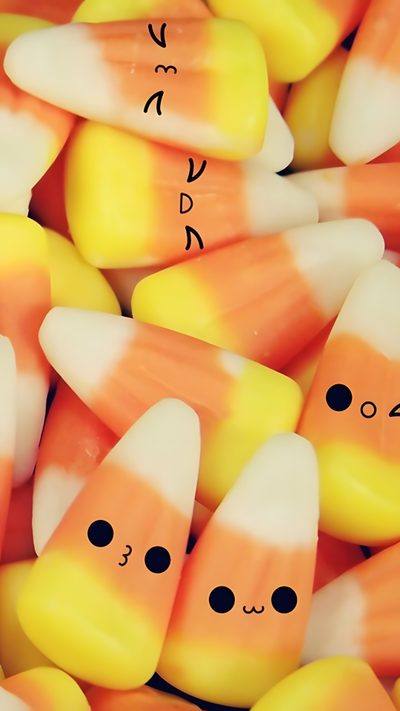 there are many candy corn with faces drawn on the top one is orange and white Halloween Candy Corn Candy Corn Background Aesthetic, Cute Candy Corn Aesthetic, Candy Corn Black Background, sandy brown