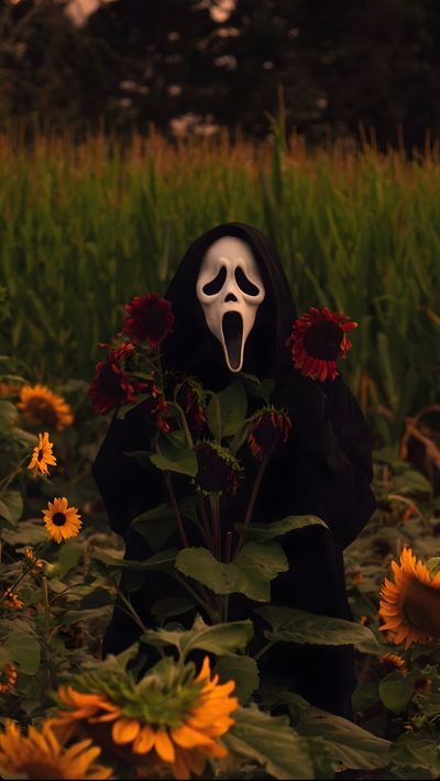 a person in a black mask with sunflowers and grass behind them is holding a white face Horror Halloween Iphone With A Person Photo Halloween, Halloween Iphone Backgrounds, Halloween Backgrounds, black