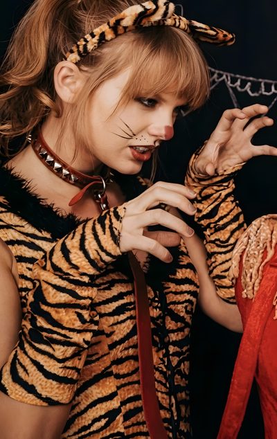 a woman dressed as a tiger is posing for the camera Halloween Taylor Swift Taylor Swift 1989 Tour, Blonde Cat, Photos Of Taylor Swift, saddle brown