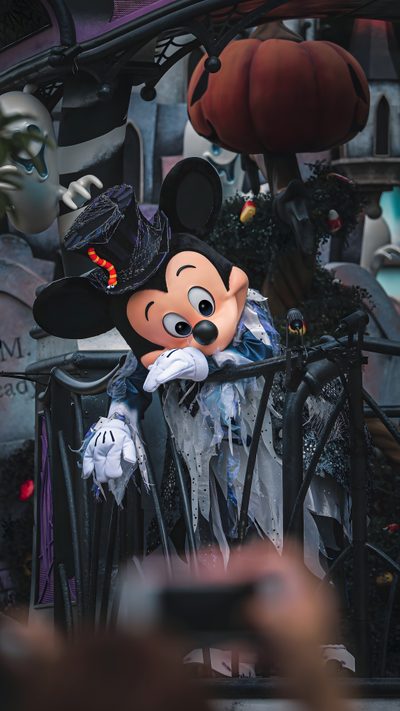 a mickey mouse dressed up as a witch in front of a halloween display at disneyland world Disneyland Halloween Aesthetic Magic Kingdom Halloween, Iphone Disneyland Halloween, Walt Disney World Halloween, dark slate gray