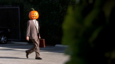 a man in a suit walking down the street with a pumpkin head on his head Dwight Halloween Dwight Pumpkin Head, The Office Halloween Episodes, The Office Spotify Covers, black