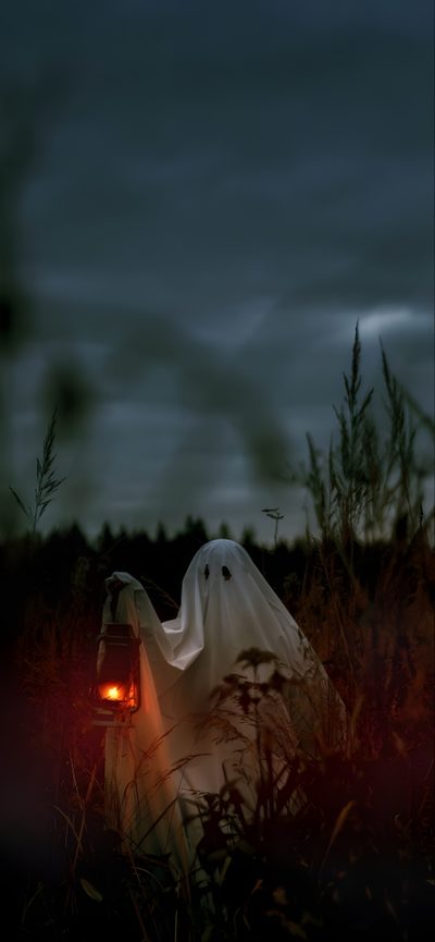 a ghost is in the middle of a field at night with its head turned to light up Aesthetic Halloween Horror Halloween Season, Spooky Stuff, Halloween Iphone Background Aesthetic, dark slate gray