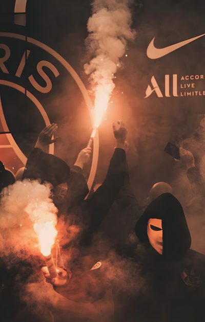 a group of people holding flarers in front of a wall with logos on it Football Halloween Psg Psg Aesthetics, Psg Logo Black Background, Psg Team For Phone, dark olive green