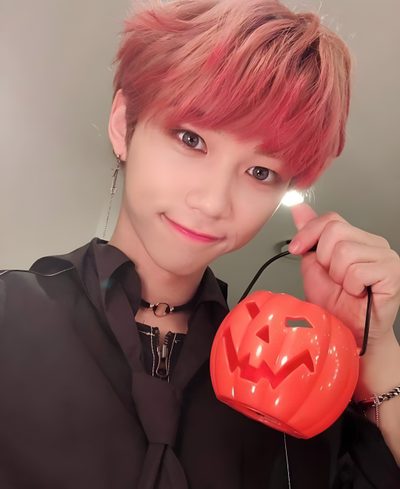 a person with pink hair holding a plastic pumpkin Felix Halloween K Pop Demon Pumpkin, Stray Kids Felix Halloween, Felix 5 Star Photocard, indian red