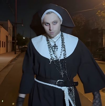 a man dressed in black and white is walking down the street at night with his hands on his hips 5sos Halloween Priest Halloween Outfit, Nun Costume Men, Men Nun Costume, Nun Outfit For Men, black