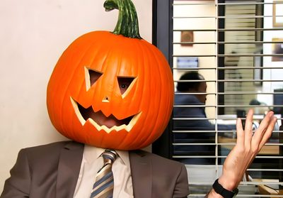 a man in a suit and tie with a pumpkin on his head Dwight Halloween Pumpkin Spice Gif, The Office Halloween, The Office Pumpkin, indian red