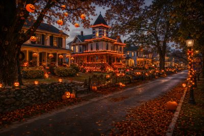 a house decorated for halloween with pumpkins on the ground and lights in the trees Halloween Town 4k Macbook High Quality Halloween, Halloween Landscape, Halloween America, black