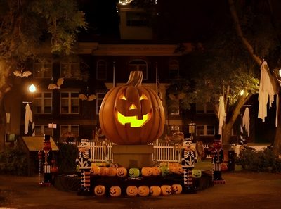 a large carved pumpkin sitting in the middle of a yard at night with decorations around it Halloweentown Pumpkin Halloween, Halloween City, Image Halloween, Black Halloween Dress,