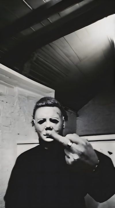 a man in black shirt pointing at something with his finger on the wall behind him Halloween Middle Finger Funny Movie, Horror Character, Michele Myers, Michael Myers Middle Finger, black