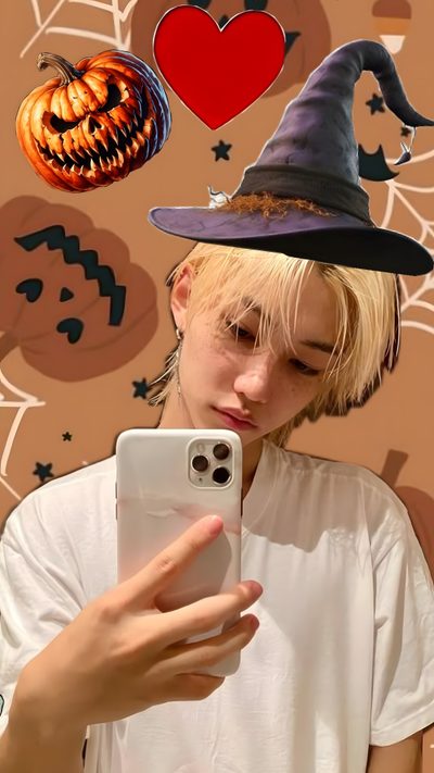a person holding a cell phone in front of a wall with halloween decorations Felix Halloween Normal, Halloween, Kids, peru