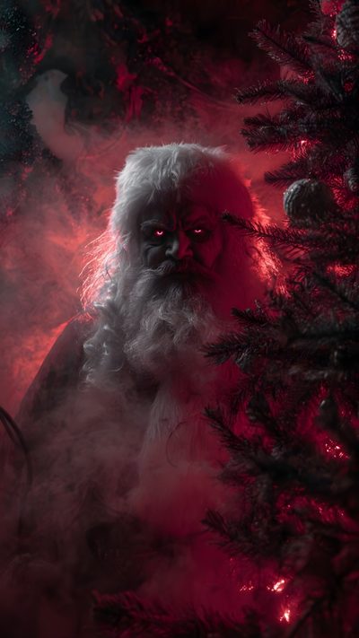 a man with long white hair and beard standing in front of a red light surrounded by trees Halloween Santa Claus Scary Santa, Gothic Fantasy Art, Dark Christmas, Scary Santa Claus, black