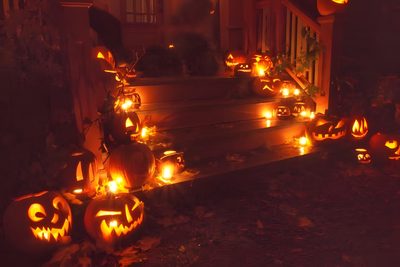 halloween pumpkins lit up on the steps in front of a house with carved faces Halloween Medium Widget Halloween Watch Your Step, Halloween Watch Your Step Ideas, Watch Your Step Halloween, maroon
