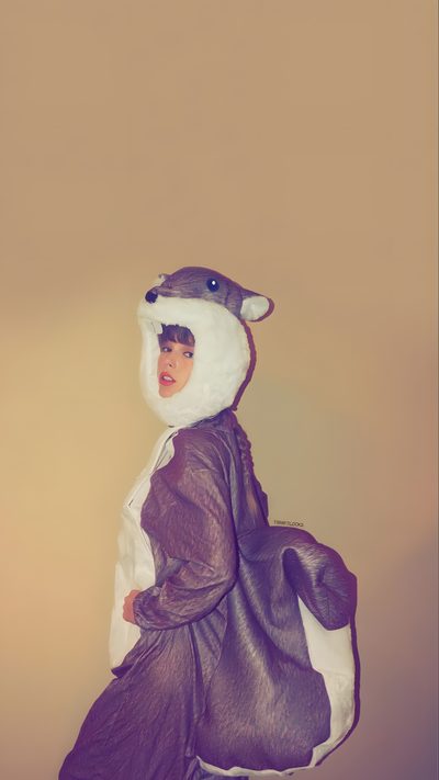 a person in a costume with an animal on their head and one hand holding a bag Taylor Swift Halloween Halloween Taylor Swift, Taylor Swift Bear Costume, Taylor Swift In Bear Costume, rosy brown
